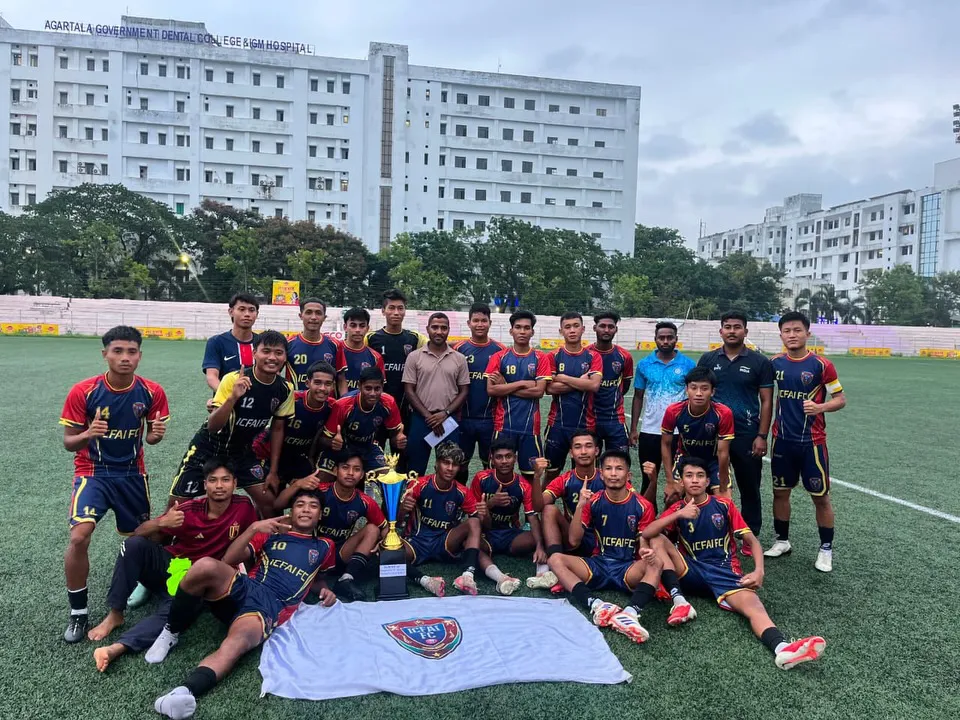 The ICFAI FC squad and staff posing with the trophy and club flag at the stadium
