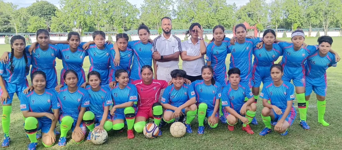 The ICFAI FC Girls Team in sky blue kit posing on the pitch with their coach and staff